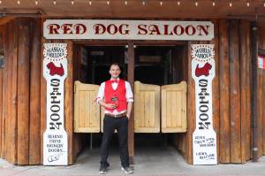 Juneau author W.R. Kozey holds his book Tall Tales of Alaska, The Red Dog Saloon: Stories from the Gold Rush & More in front of the Red Dog Saloon on Sunday. (Jasz Garrett / Juneau Empire)