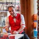 Juneau author W.R. Kozey smiles after signing a copy of his book Tall Tales of Alaska, The Red Dog Saloon: Stories from the Gold Rush & More at his first signing event on Sunday. (Jasz Garrett / Juneau Empire)