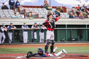 Juneaus Nate Fick leaps to make a catch while another Eagle River run scores during the opening game Thursday of the Division I Alaska School Activities Association Baseball State Championships. (Stephanie Burgoon/Alaska Sports Report)