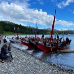 A crowd greets a group of traditional canoes landing at the Auke Village Recreation Area on Tuesday. (Laurie Craig / Juneau Empire)