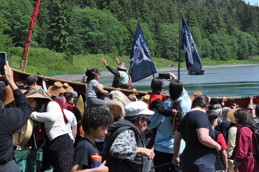 Master Carver Wayne Price is hoisted ashore while sitting in his dugout canoe on the shoulders of supporters after their landing Tuesday at the Auke Village Recreation Area. Price taught others how to carve a dugout. (Laurie Craig / Juneau Empire)