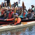 Paddlers in traditional Tlingit canoes, plus a smaller Bering Sea kayak guided by Lou Logan, arrive at the Auke Village Recreation Area at midday Tuesday following their journey down the northern part of the Inside Passage. (Laurie Craig / Juneau Empire)
