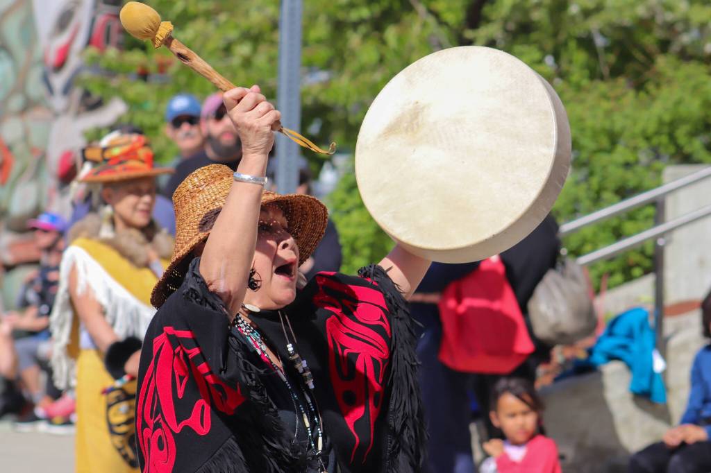 Leader of the Yèes Ku.oo dance group, Nancy Barnes, drums during the parade. (Jasz Garrett / Juneau Empire)