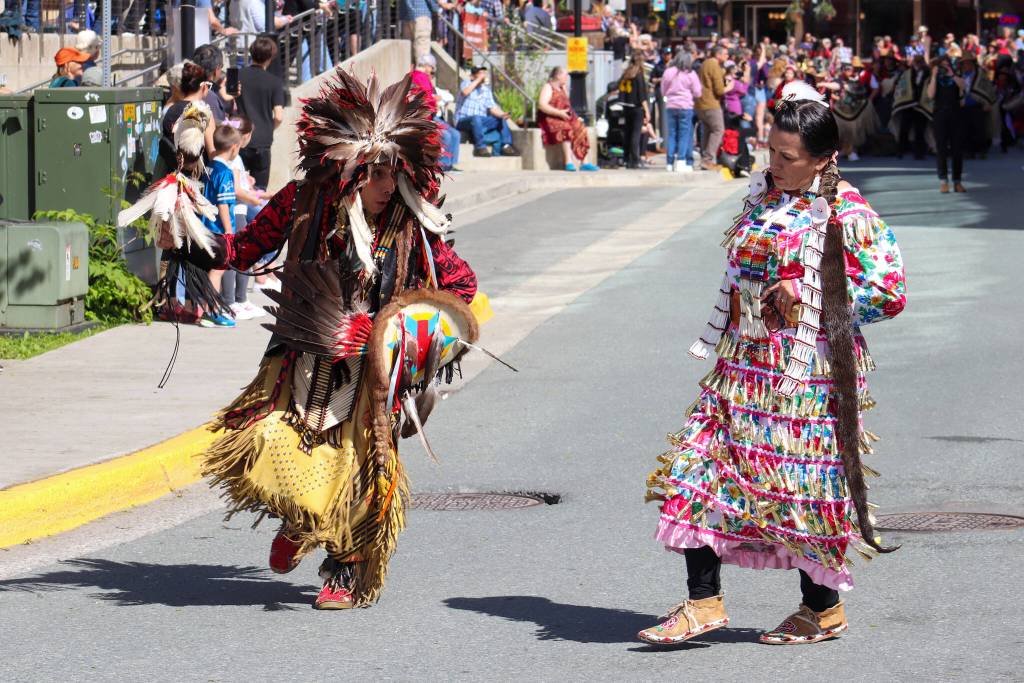 Thomas Yellow Horse Davis and Kimberly Dominguez parade through downtown Juneau. (Jasz Garrett / Juneau Empire)