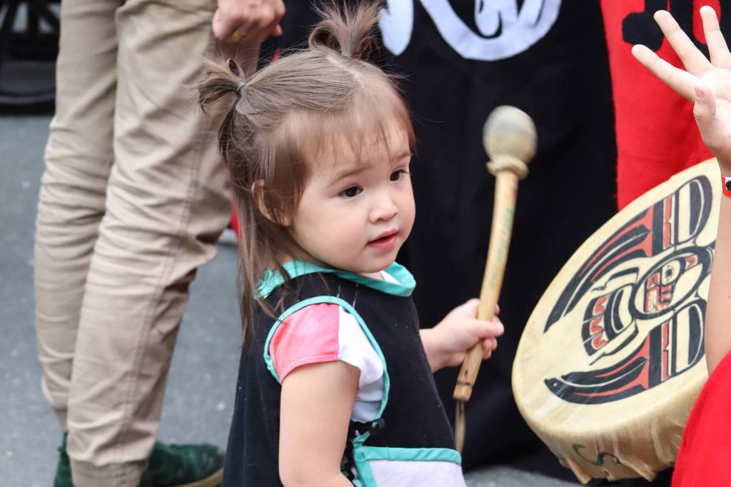 Srivani Brown from Yakutat, 2, drums during the Grand Exit for Celebration. (Jasz Garrett / Juneau Empire)