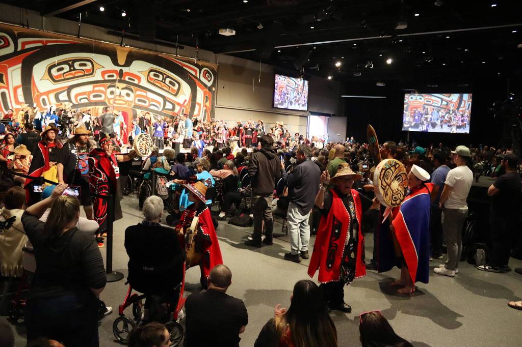 A capacity crowd cheers dancers as they pass through the main ballroom at Centennial Hall during the Grand Exit ceremony on Saturday night. (Mark Sabbatini / Juneau Empire)
