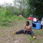 Curtis Davis sharpens a spike at his makeshift campsite near Juneau International Airport on Sunday. (Mark Sabbatini / Juneau Empire)