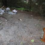 Litter from what appears to be a camping spot in the woods near Vintage Business Park is seen on Sunday. (Mark Sabbatini / Juneau Empire)