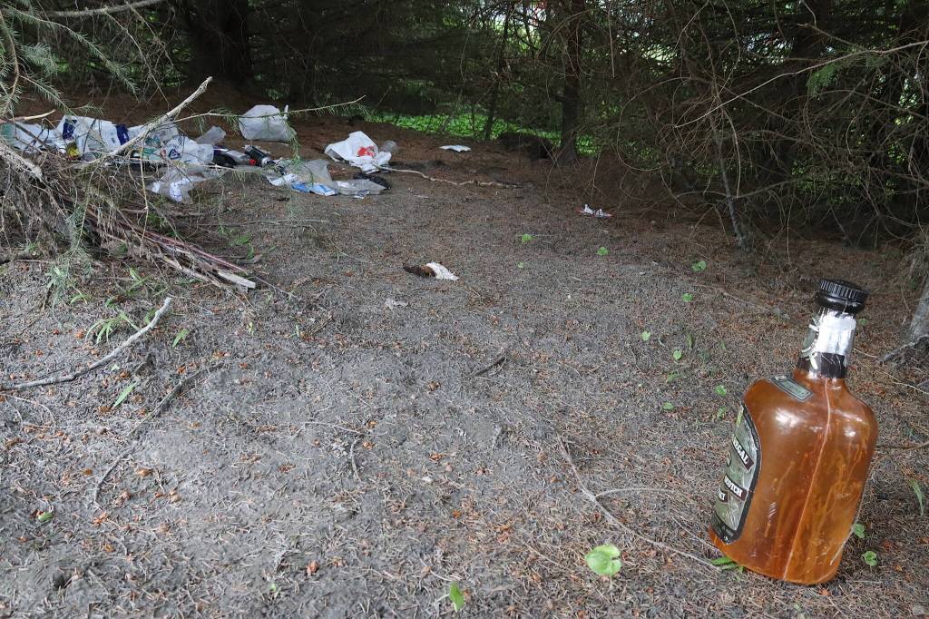 Litter from what appears to be a camping spot in the woods near Vintage Business Park is seen on Sunday. (Mark Sabbatini / Juneau Empire)