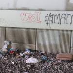 Items are scattered at a spot under the Brotherhood Bridge, where people experiencing homeless have camped this summer. (Jasz Garrett / Juneau Empire)