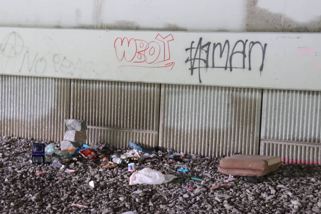 Items are scattered at a spot under the Brotherhood Bridge, where people experiencing homeless have camped this summer. (Jasz Garrett / Juneau Empire)