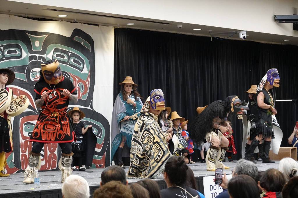 Four dancers manipulate their carved masks to open and shut the eyelids on the painted wooden masks carved by David A. Boxley of Git Hoan as dancers sing and drum on Saturday at Elizabeth Peratrovich Hall. (Laurie Craig / Juneau Empire)
