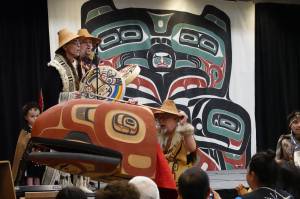 David A. Boxley, wearing a Ravenstail-trimmed robe, and his son David R. Boxley sing and drum in Elizabeth Peratrovich Hall on Saturday afternoon as Metlakatlas Git Hoan dancers perform a canoe paddling dance featuring a large carved headdress created by Git Hoans senior Boxley. (Laurie Craig / Juneau Empire)