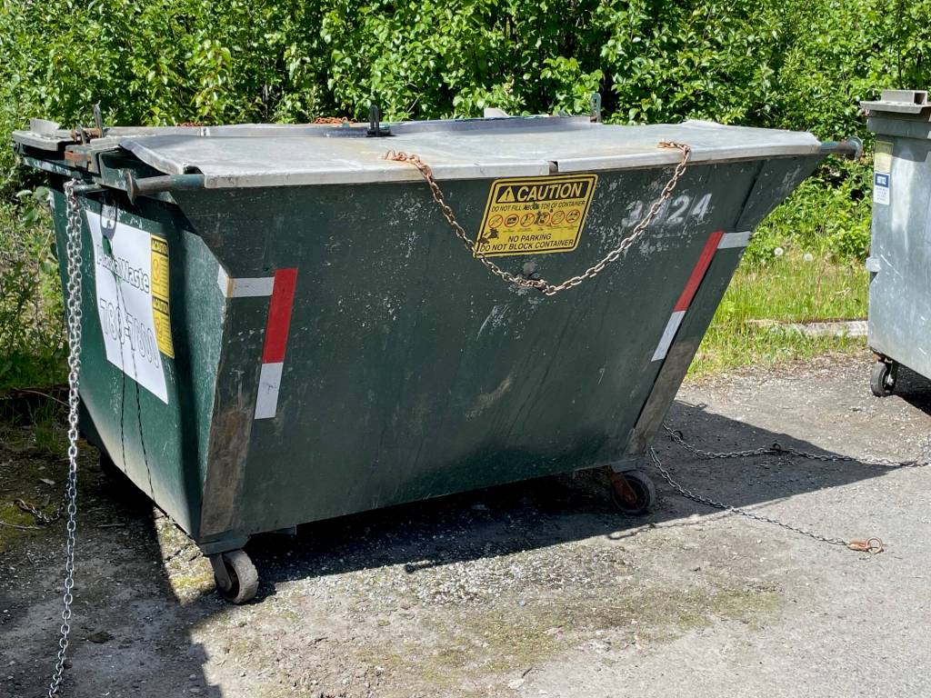 Dumpsters should be anchored to a concrete pad by chains and cable locks on strong metal lids. (Laurie Craig / Juneau Empire)
