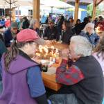 Patty Collins and Dave Hanna gather with others at a tribute party for former Eaglecrest Ski Area Manager Dave Scanlan at an expanded food court on Franklin Street on Friday night. (Mark Sabbatini / Juneau Empire)