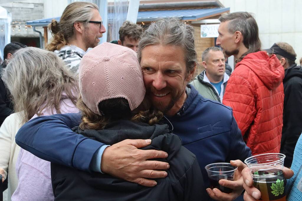 Former Eaglecrest Ski Area Manager Dave Scanlan hugs a supporter during a tribute party to him at an expanded food court on Franklin Street on Friday night. (Mark Sabbatini / Juneau Empire)