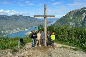 Workers stand next to the Father Browns Cross after they reinstalled it at an overlook site on Mount Roberts on Wednesday. (Photo courtesy of Hugo Miramontes)