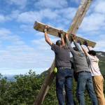 Workers lift the Father Browns Cross into a newly dug hole on Mount Roberts on Wednesday morning. (Photo courtesy of Hugo Miramontes)