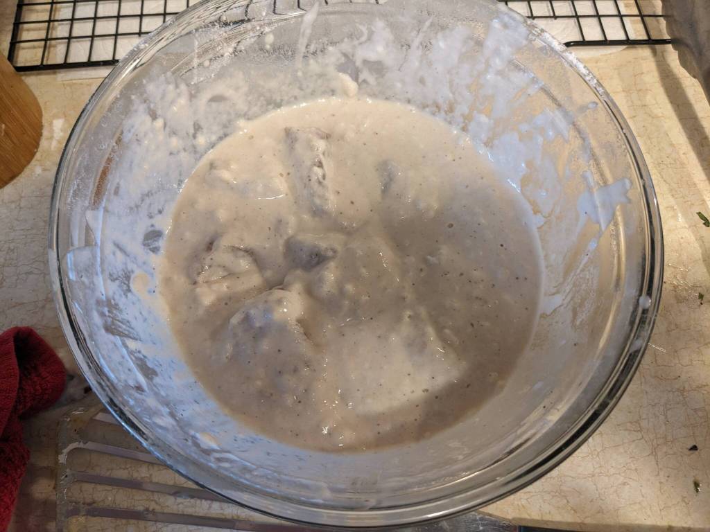 Covering fish with batter in preparation for frying. (Photo by Patty Schied)