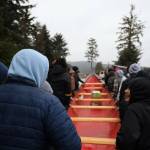 Students begin the commemoration walk outside Chatham School District to push the 30-foot-long dugout canoe down to Front Street in October of 2022. It is the first dugout canoe made in Angoon since the U.S. Navy bombardment. (Clarise Larson / Juneau Empire file photo)