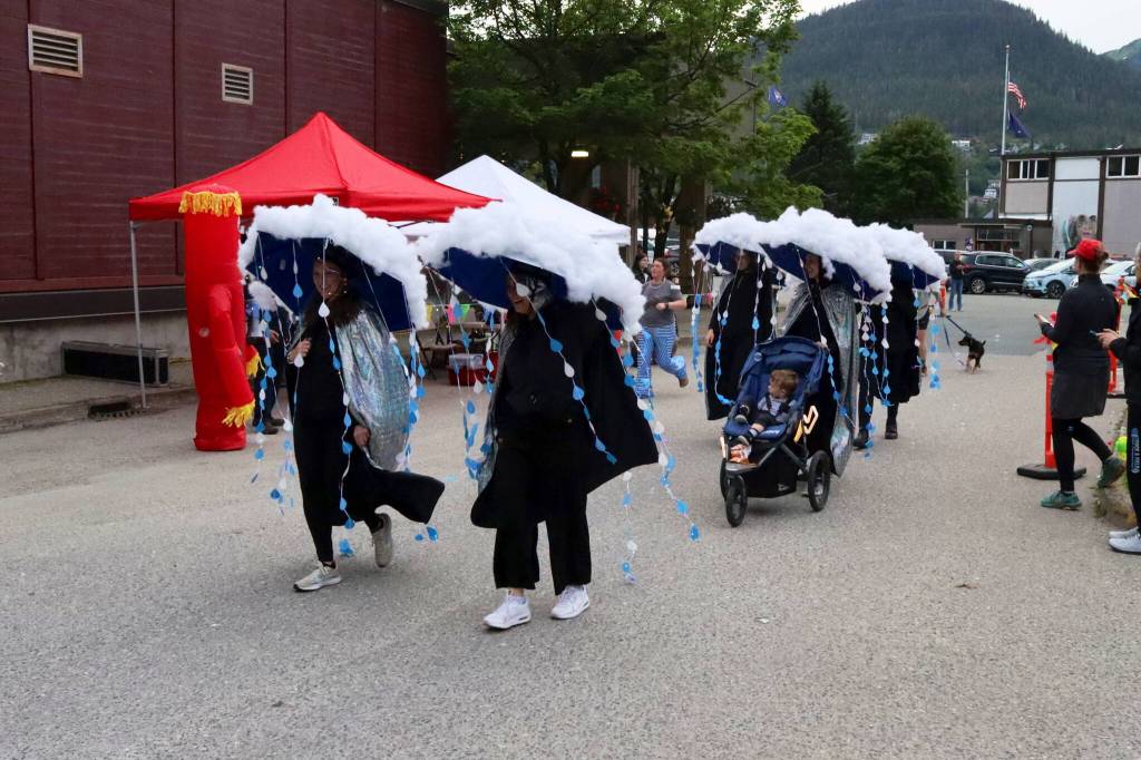 Five adults and a tot calling themselves the Juneau Forecast head out from the starting line of the Only Fools Run At Night to take part in the one-mile course on Friday at Centennial Hall. (Mark Sabbatini / Juneau Empire)