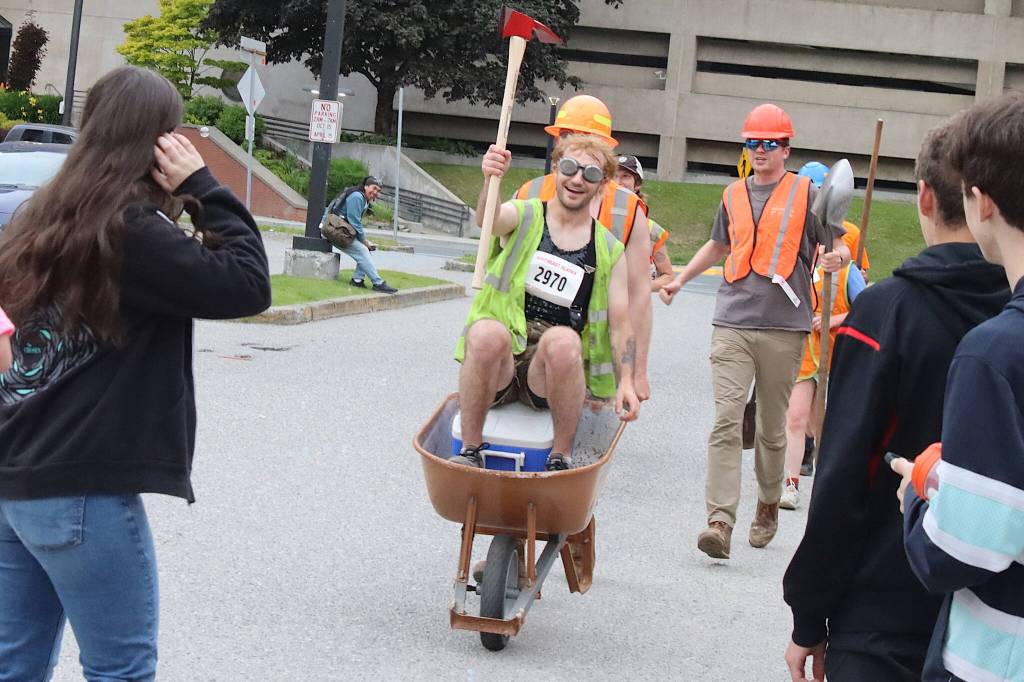 Members of the Trail Mix team reach the finish line of the Only Fools Run At Night on Friday at Centennial Hall. (Mark Sabbatini / Juneau Empire)
