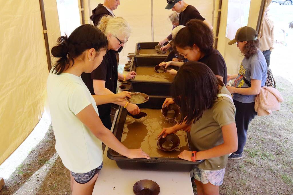 People try their luck at panning for gold during Juneau Gold Rush Days on Saturday at Savikko Park. (Mark Sabbatini / Juneau Empire)