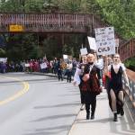 Pro-choice rally participants chant and carry signs as they walk along Calhoun Avenue toward the Governors Residence on Saturday. (Mark Sabbatini / Juneau Empire)