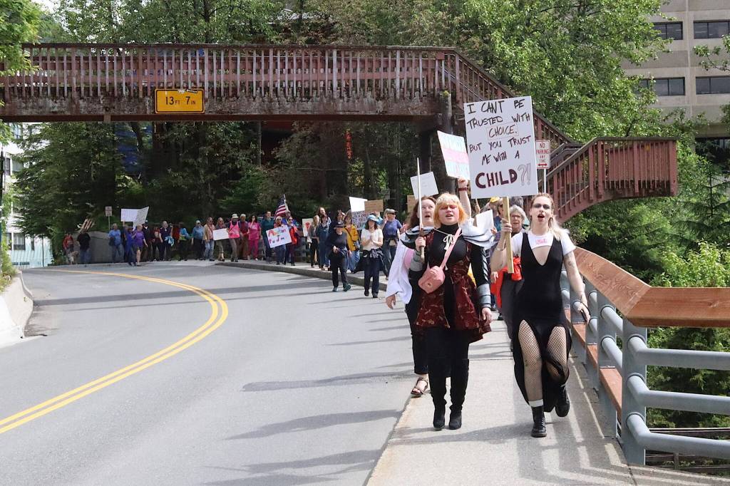 Pro-choice rally participants chant and carry signs as they walk along Calhoun Avenue toward the Governors Residence on Saturday. (Mark Sabbatini / Juneau Empire)