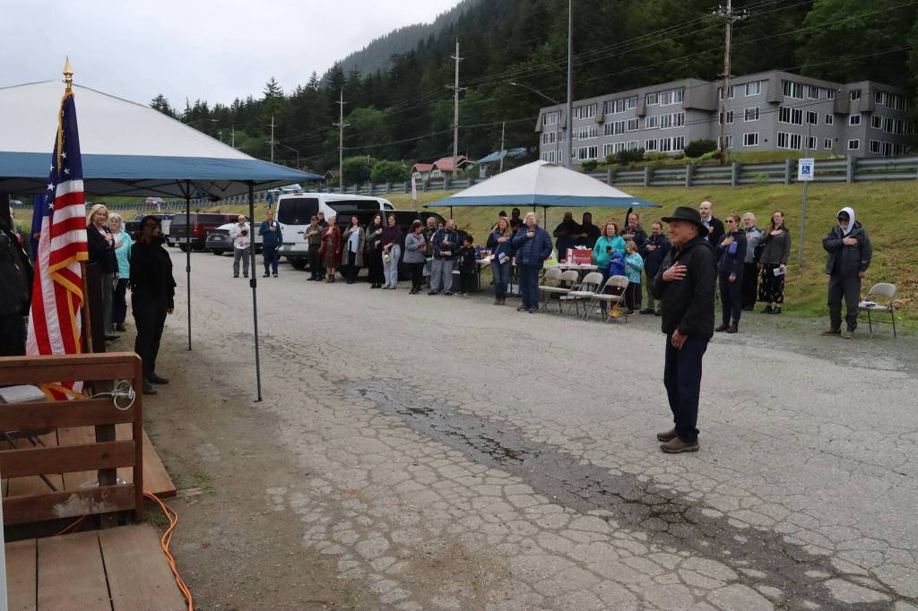 About 40 people listen to the national anthem during a ribbon-cutting ceremony Monday to celebrate the completion of the third of four stages of reconstruction of the 60-year-old Aurora Harbor. (Mark Sabbatini / Juneau Empire)