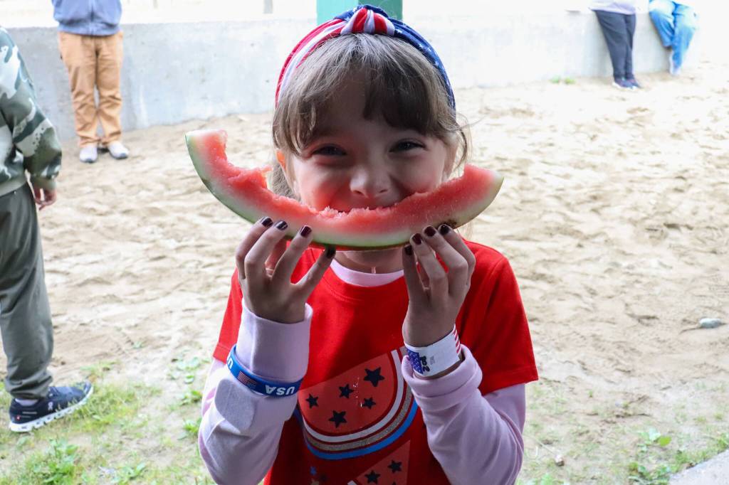 Marie Markel, 7, holds up her watermelon at the Douglas Fourth of July Committees annual community picnic on Wednesday. (Jasz Garrett / Juneau Empire)