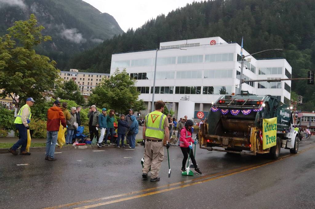Staff and volunteers collect trash for the Alaska Waste truck that is the final float in Juneaus Fourth of July parade on Thursday morning. (Mark Sabbatini / Juneau Empire)
