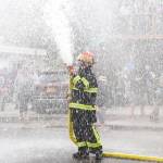 Capital City Fire/Rescue Captain Jayme Johns sprays the crowd after winning the firemens hose race on July 4. (Jasz Garrett / Juneau Empire)