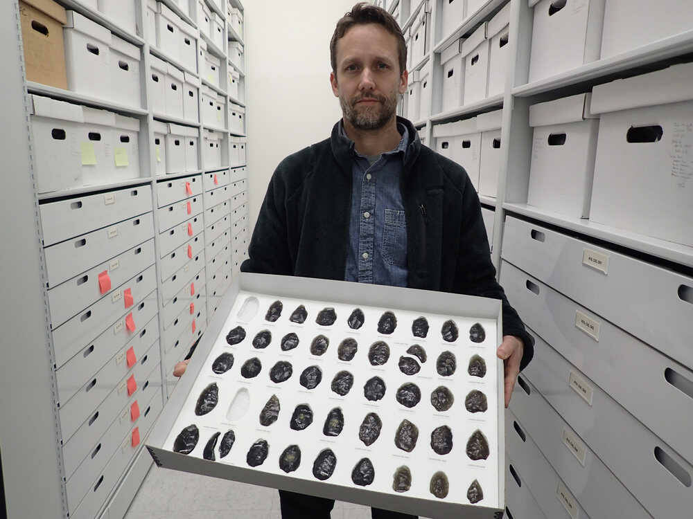 Archaeologist Jeff Rasic holds a tray of obsidian tools found in the Nogahabara Dunes west of the Koyukuk River. (Photo by Ned Rozell)