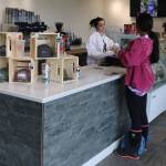 Disney Williams (right) orders coffee from Lorelai Bingham from the Flying Squirrel coffee stand at Juneau International Airport on Thursday. (Mark Sabbatini / Juneau Empire)