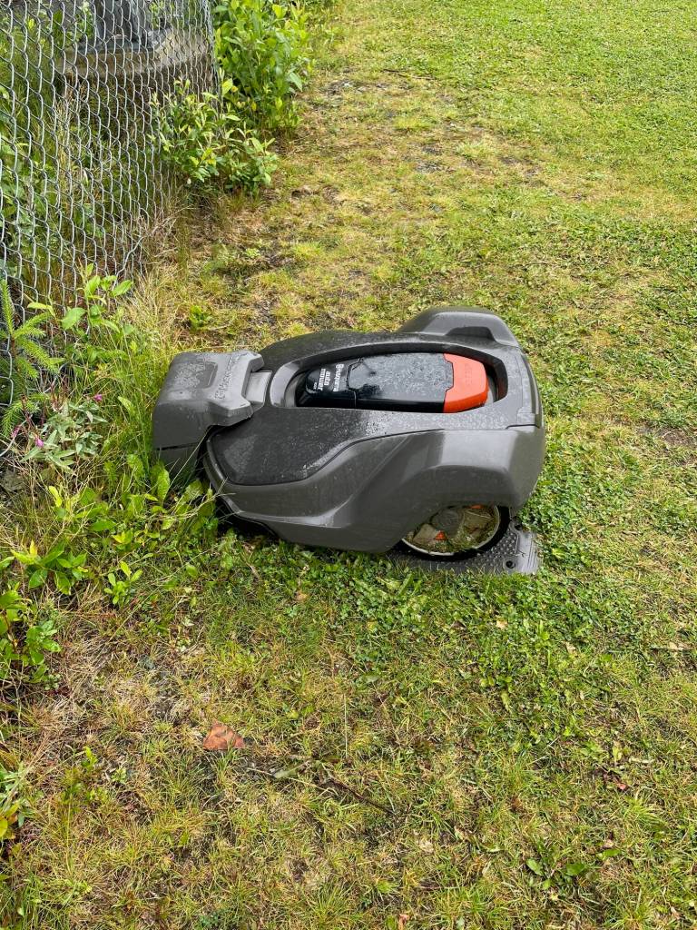 One for four Juneau School District battery electric robotic lawnmowers is being recharged near the expansive lawn it cuts at Thunder Mountain Middle School. (Laurie Craig / Juneau Empire)