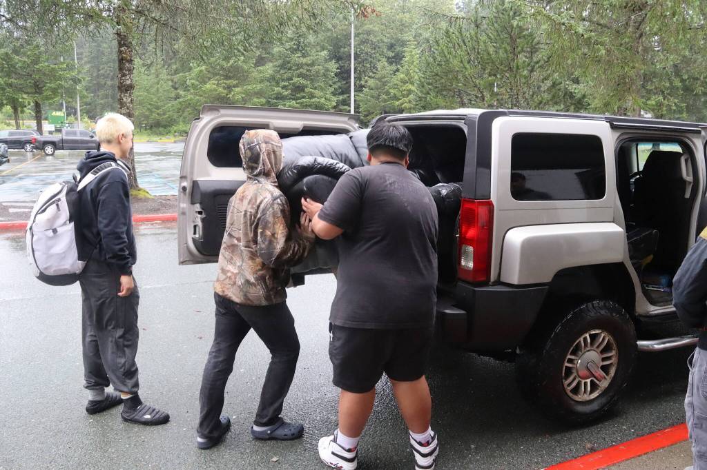 Members of Juneaus high school football team load a couch into a vehicle in front of the former Floyd Dryden Middle School on Saturday. The players helped with the setup and sales during the multiday effort to get rid of the some of the schools surplus items. (Mark Sabbatini / Juneau Empire)