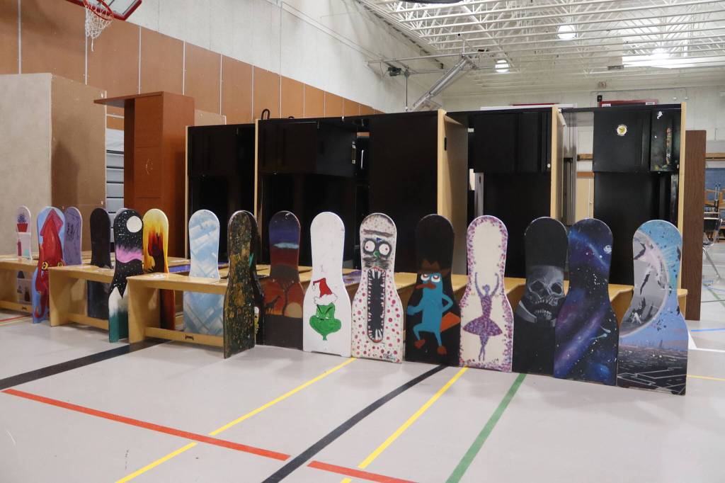 Artist benches painted by students are offered for sale in the gym of the former Floyd Dryden Middle School on Saturday. (Mark Sabbatini / Juneau Empire)