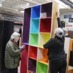 Shelley McNurney (right) and Tami Hesseltine examine a muticolor storage shelf in the gym of the former Floyd Dryden Middle School on Saturday, where surplus items from the school were being sold to residents and given away to nonprofit entities. (Mark Sabbatini / Juneau Empire)