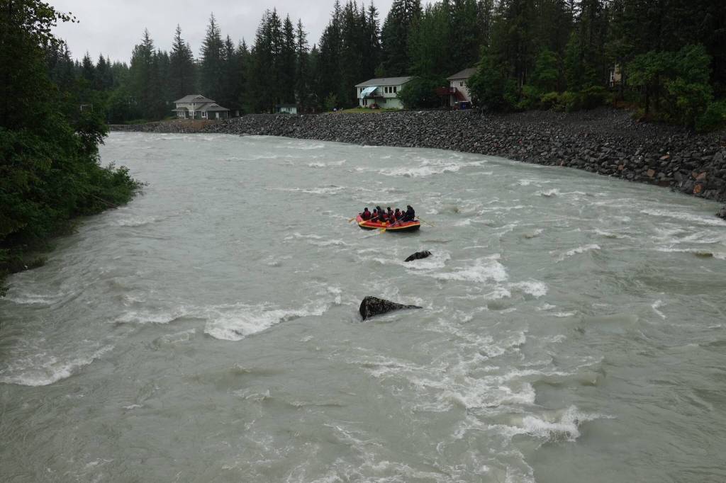 Rafters on Sunday afternoon float past homes along the Mendenhall River that were exposed to record flooding last August, damaging or destroying many of them. Rock fill has been placed along the bank to protect against further erosion and the river remained well below last years flood levels. (Laurie Craig / Juneau Empire)