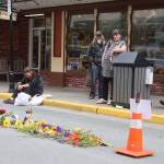 Friends of Steven Kissack, a longtime Juneau resident experiencing homelessness, gather at a memorial on Front Street on Tuesday evening at the site where he was fatally shot by police on Monday. (Mark Sabbatini / Juneau Empire)