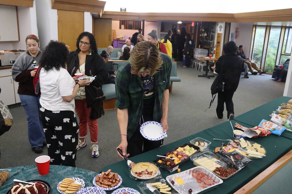 People gather in the reception hall of Resurrection Lutheran Church on Tuesday evening during a vigil for Steven Kissack, a longtime Juneau resident experiencing homelessness who was fatally shot by police on Monday. (Mark Sabbatini / Juneau Empire)