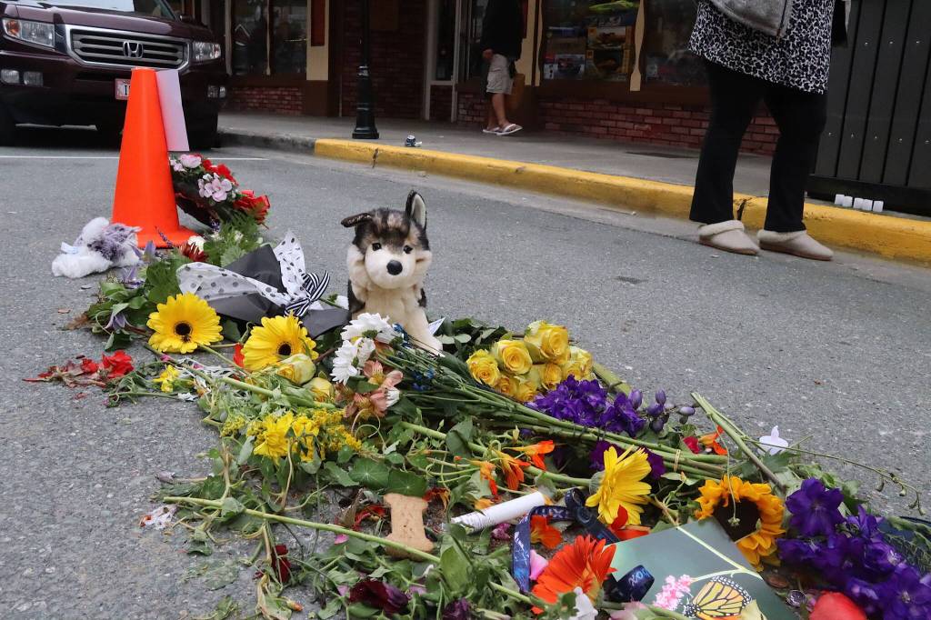 Flowers, notes, cash donations and other items are placed Tuesday evening at a memorial for Steven Kissack, a longtime Juneau resident experiencing homelessness, at the spot he was fatally shot by police on Monday. The stuffed malamute is in recognition of his dog Juno, who was present when the shooting occurred and is now being cared for by animal control officials. (Mark Sabbatini / Juneau Empire)