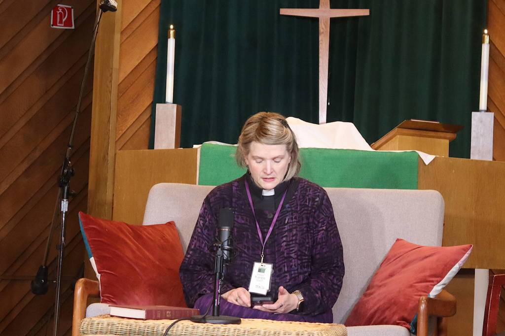 The Rev. Karen Perkins reads a bible passage while presiding over a vigil at Resurrection Lutheran Church for Steven Kissack, a longtime Juneau resident experiencing homelessness who was fatally shot by police on Monday. (Mark Sabbatini / Juneau Empire)