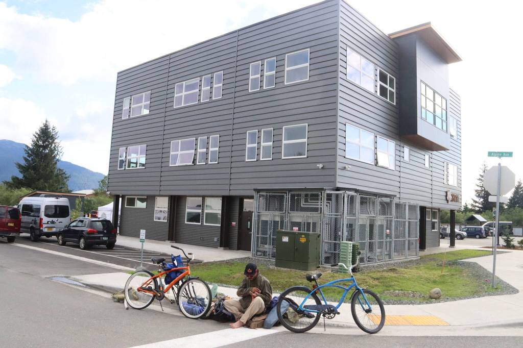 Garrett Derr, a local resident experiencing homelessness, sits on the curb near the Teal Street Center shortly after a ribbon-cutting ceremony Thursday afternoon. (Mark Sabbatini / Juneau Empire)