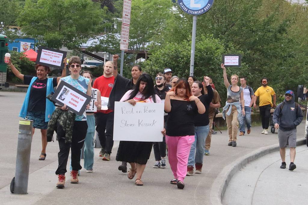 Members of a protest that started at the Alaska State Capitol approach another group at the downtown Juneau Public Library also protesting the death of Steven Kissack last Monday. (Mark Sabbatini / Juneau Empire)