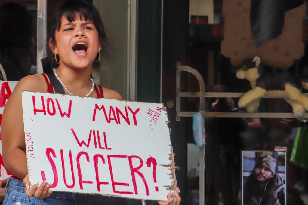 Ariilana Shodda-Lee chants in a protest held for Juneau resident Steven Kissack on Sunday. A memorial for him can be partially seen behind her on Front Street. (Jasz Garrett / Juneau Empire)