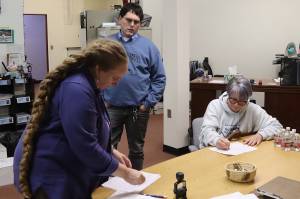 Michele Stuart Morgan (right), a Juneau Board of Education candidate, signs a qualifying petition for Jeff Redmond (center), who is also seeking one of three school board seats in the Oct. 1 municipal election, just before Mondays filing deadline at City Hall. At left, Deputy Municipal Clerk Diane Cathcart processes last-minute paperwork filed by candidates. (Mark Sabbatini / Juneau Empire)