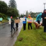 Spectators with signs cheer participants in the Juneau Marathon and Half Marathon on Saturday. (Mark Sabbatini / Juneau Empire)