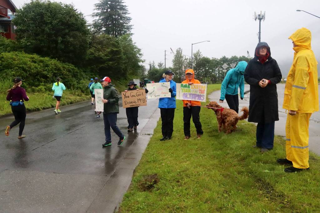 Spectators with signs cheer participants in the Juneau Marathon and Half Marathon on Saturday. (Mark Sabbatini / Juneau Empire)